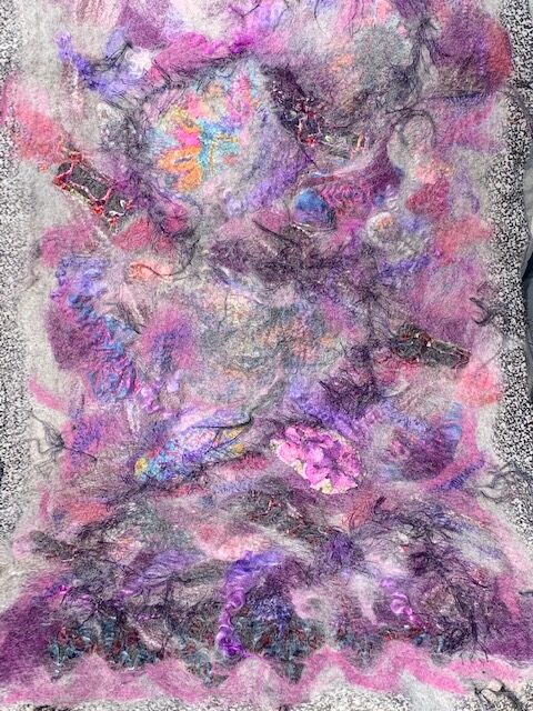 purple and gray fibers laid out for felting