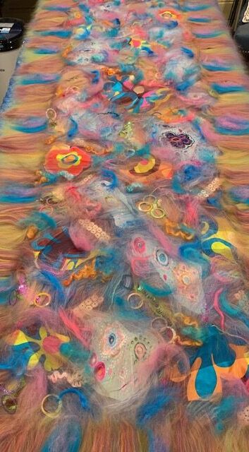 bright pastel fibers laid out for felting